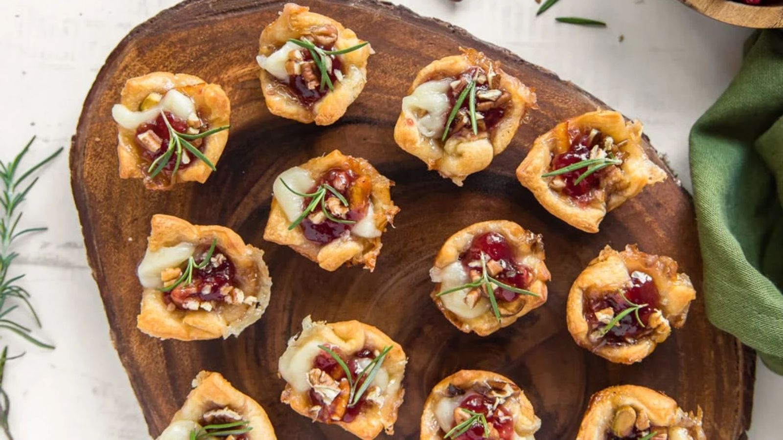 Cranberry brie bites on a wooden board.