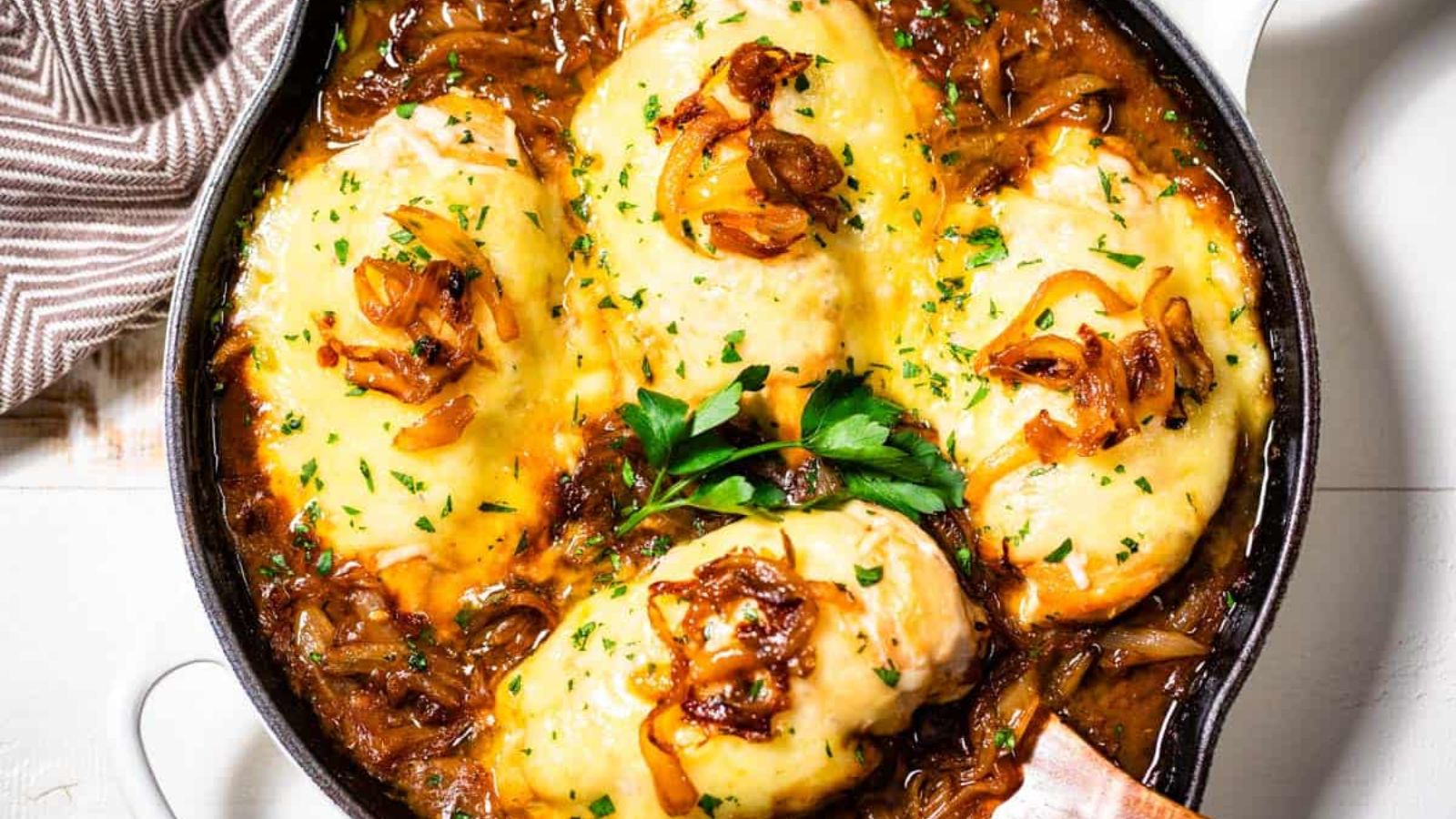 French onion chicken with cheese on top.