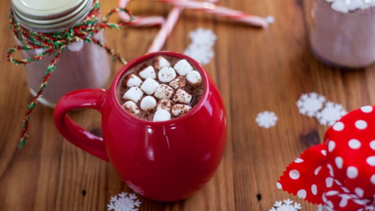 Hot chocolate in a red cup topped with marshmallows.