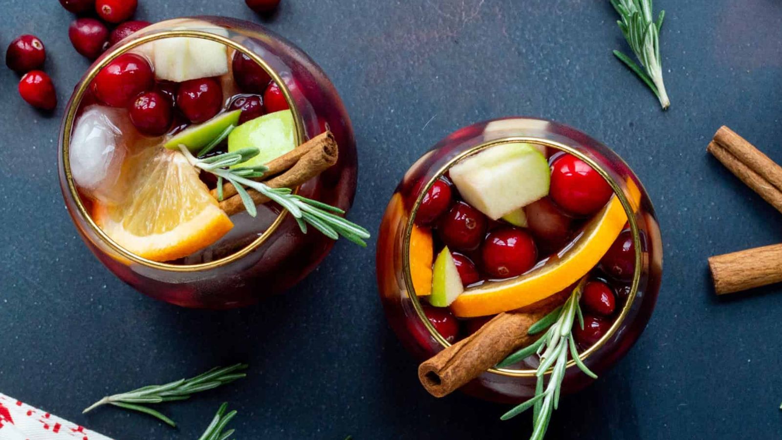 Two glasses of sangria with cranberries.