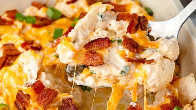 Spoonful of cheese casserole over the baking dish.