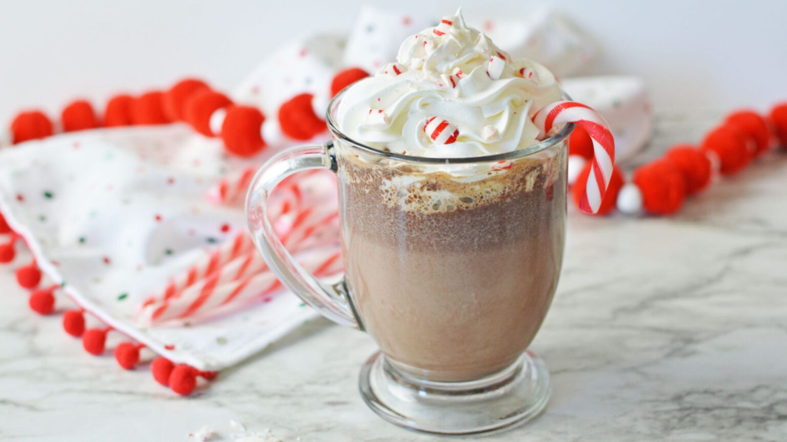 Hot chocolate in a glass with whipped cream.