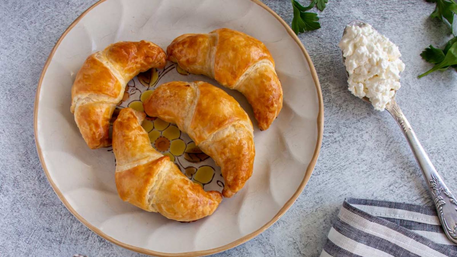 Four croissants on a plate.