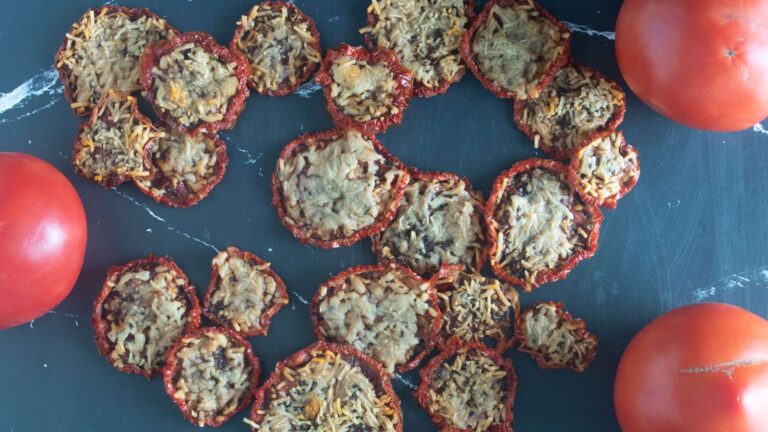 Parmesan tomato chips on a black board.