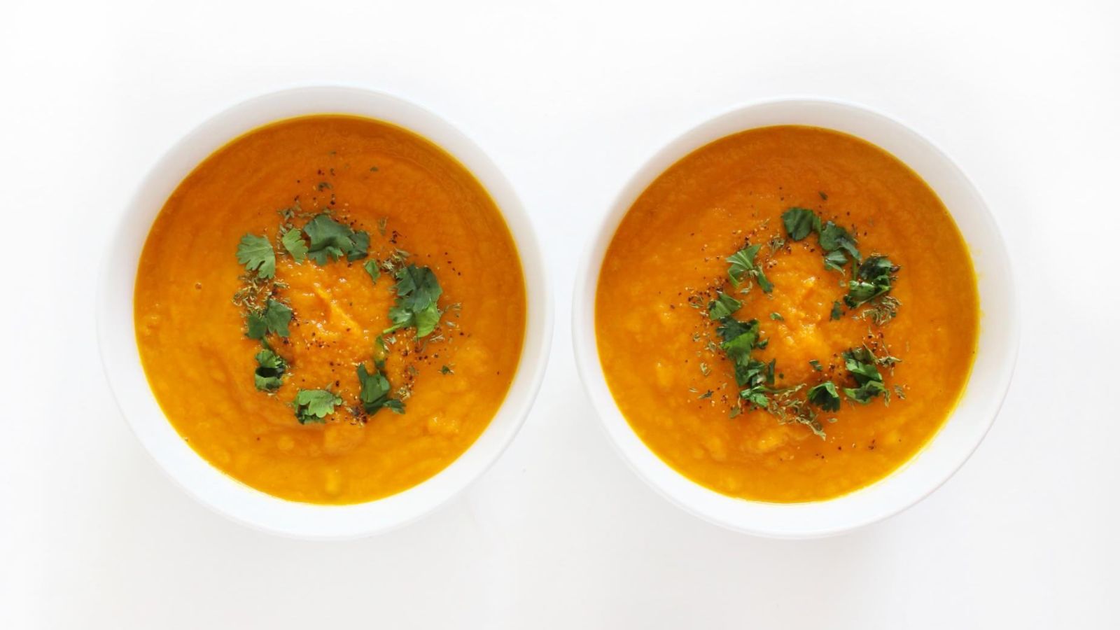 Two bowls of carrot soup.