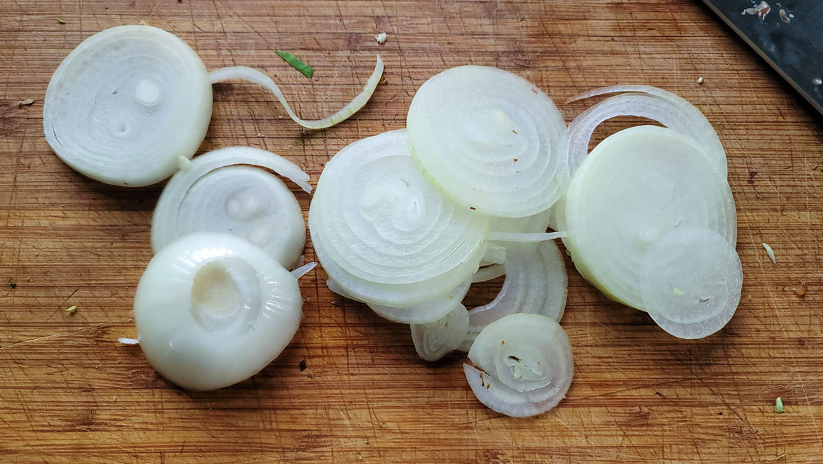 Slice onions on a board.