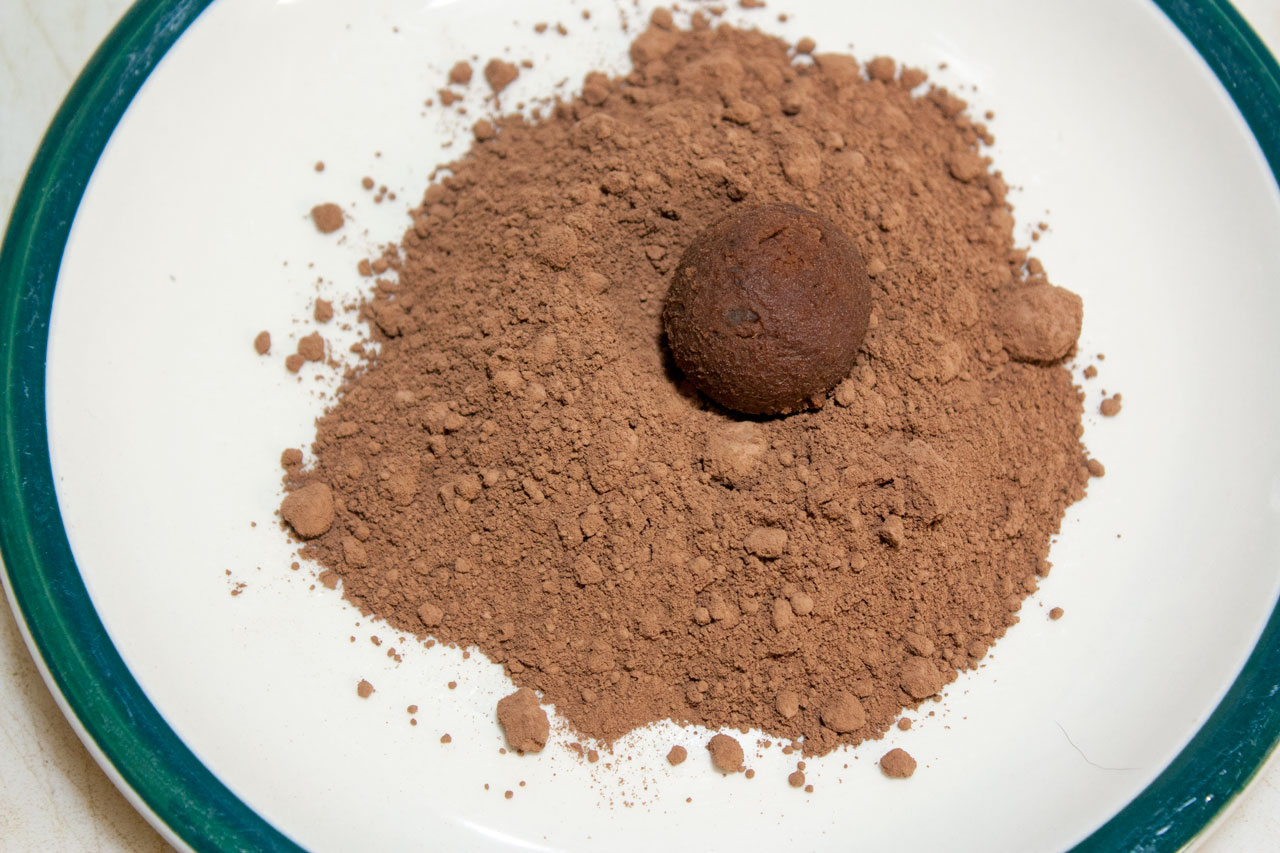 Rolling truffles in cocoa powder.
