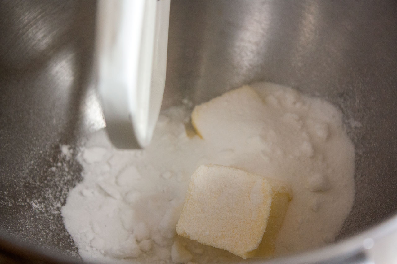 Butter and sugar added to a mixing bowl.