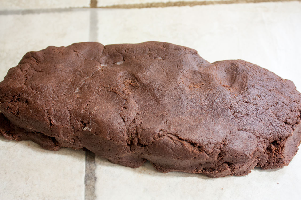 Dough formed into a log on a piece of waxed paper.