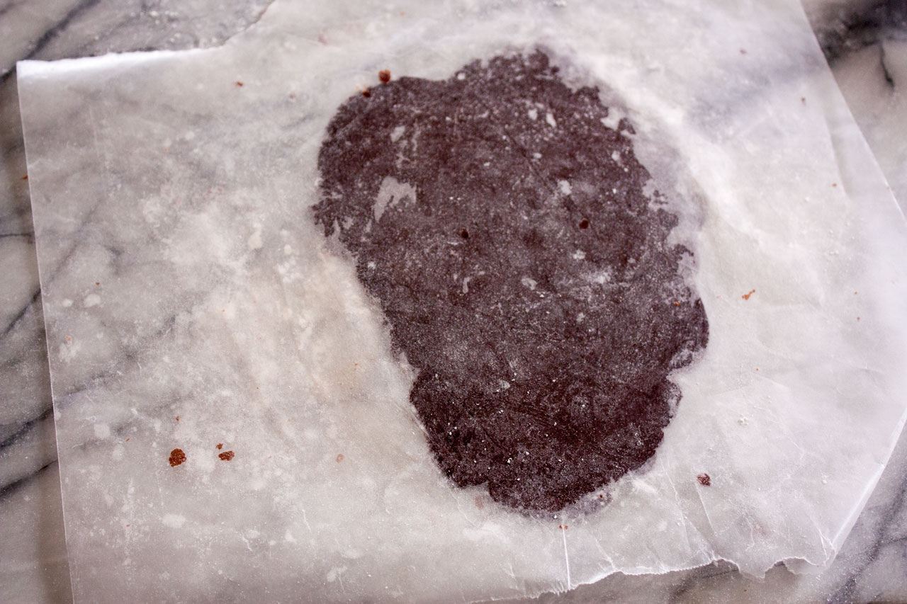 Rolled dough between sheets of waxed paper.