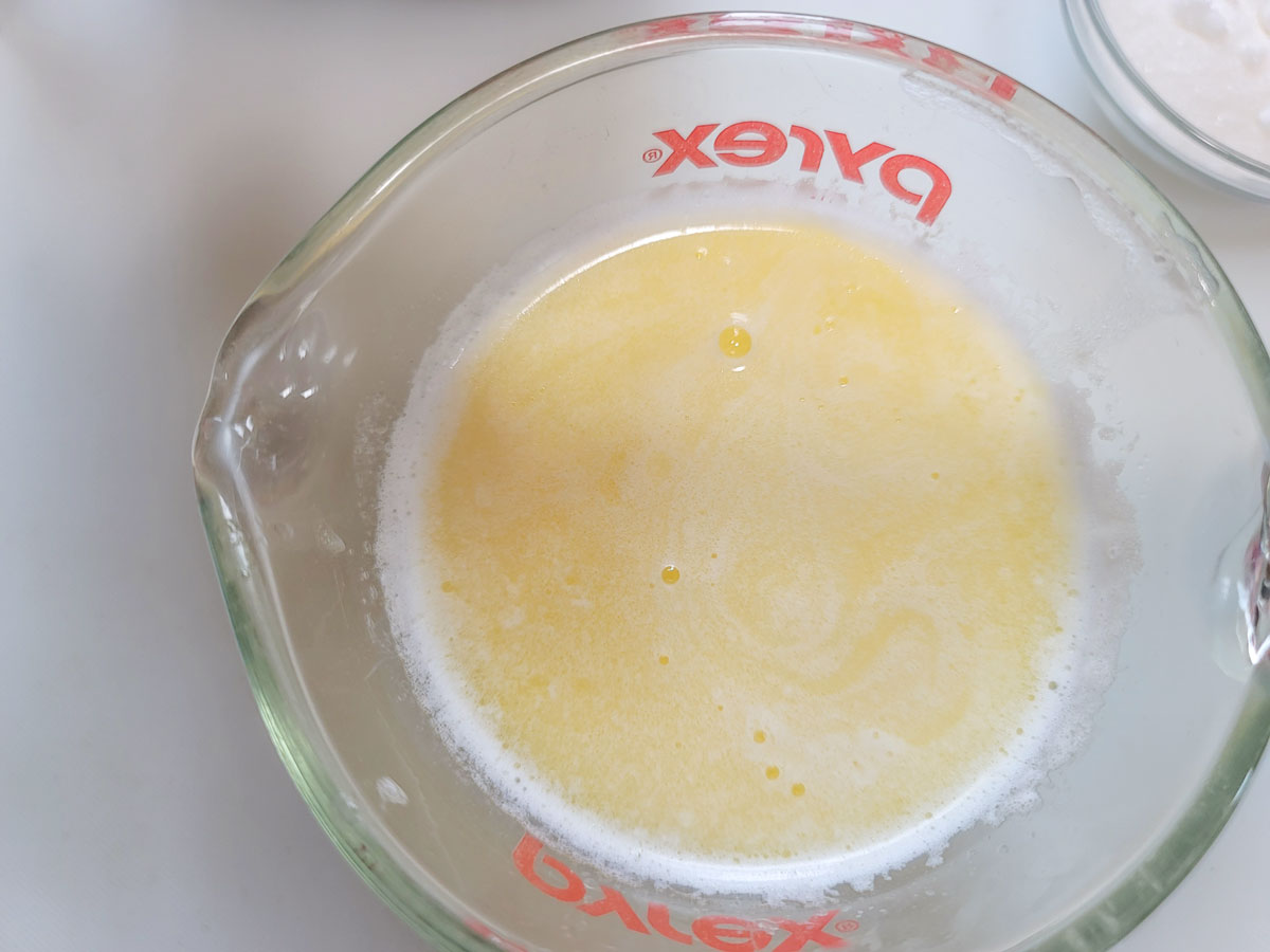 Heated milk and butter in a measuring cup.