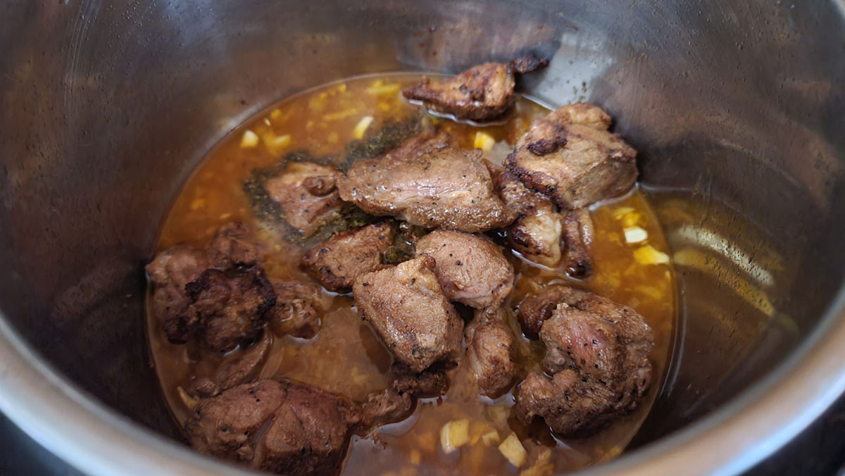 Lamb added to the pot.