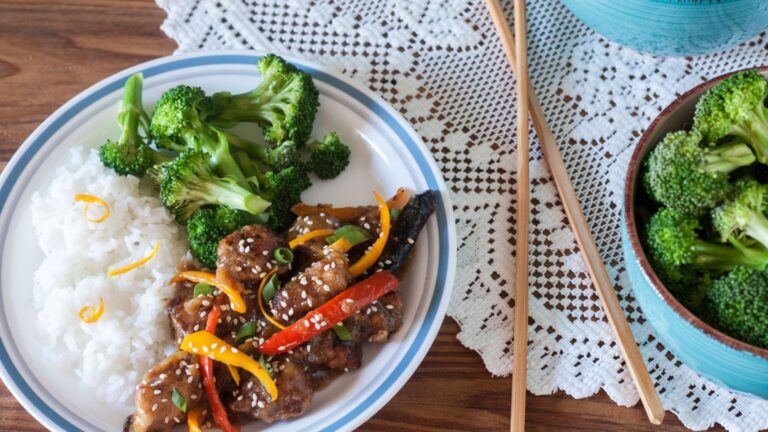 Stir fry with broccoli and rice on a white plate with a blue rim.