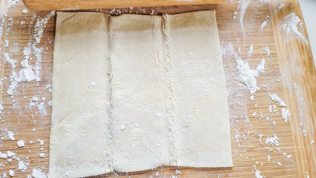 Puff pastry sheet laid out on the floured board.