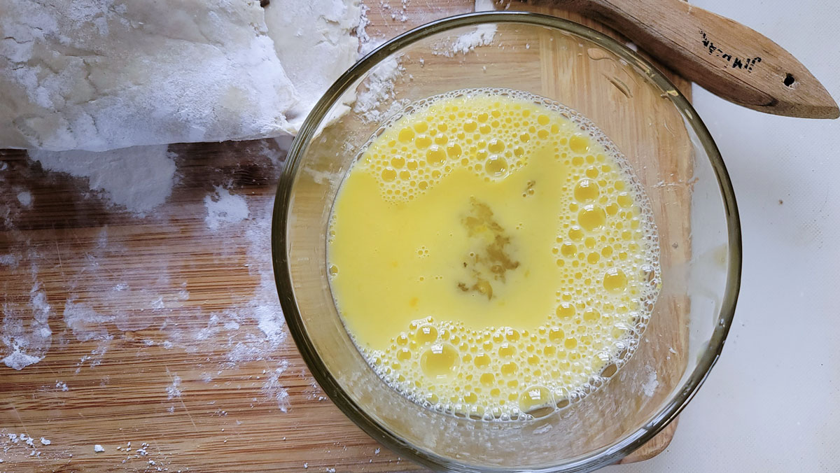 Egg wash in a small bowl.