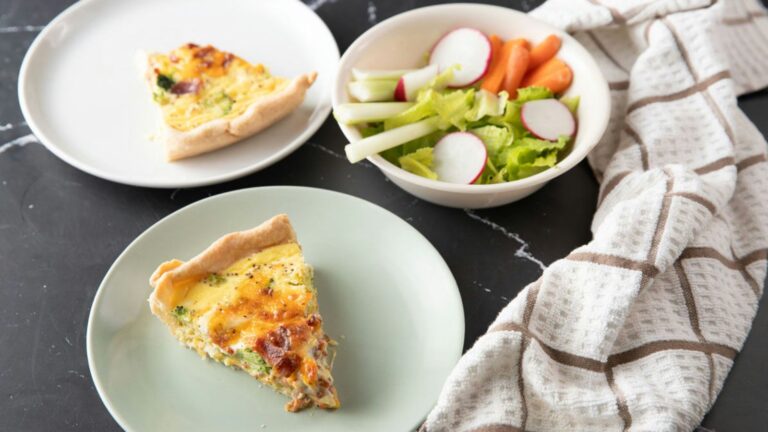 Pieces of quiche on small plates with a salad in a bowl.