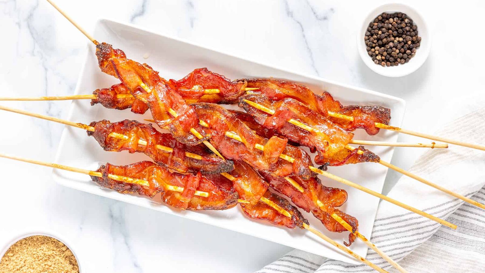 Candied bacon skewers on a plate.