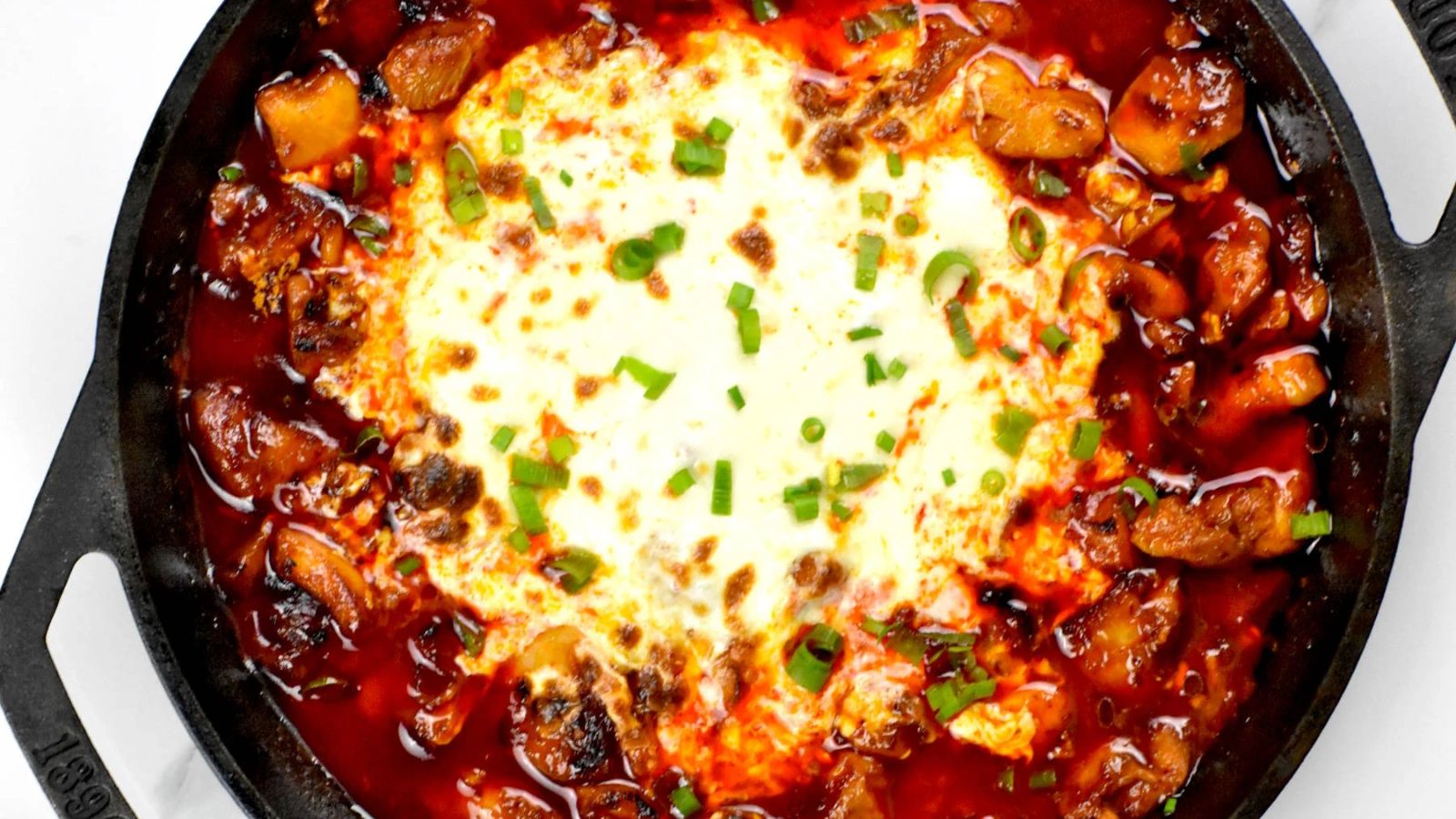 Chicken with sauce and cheese on top.