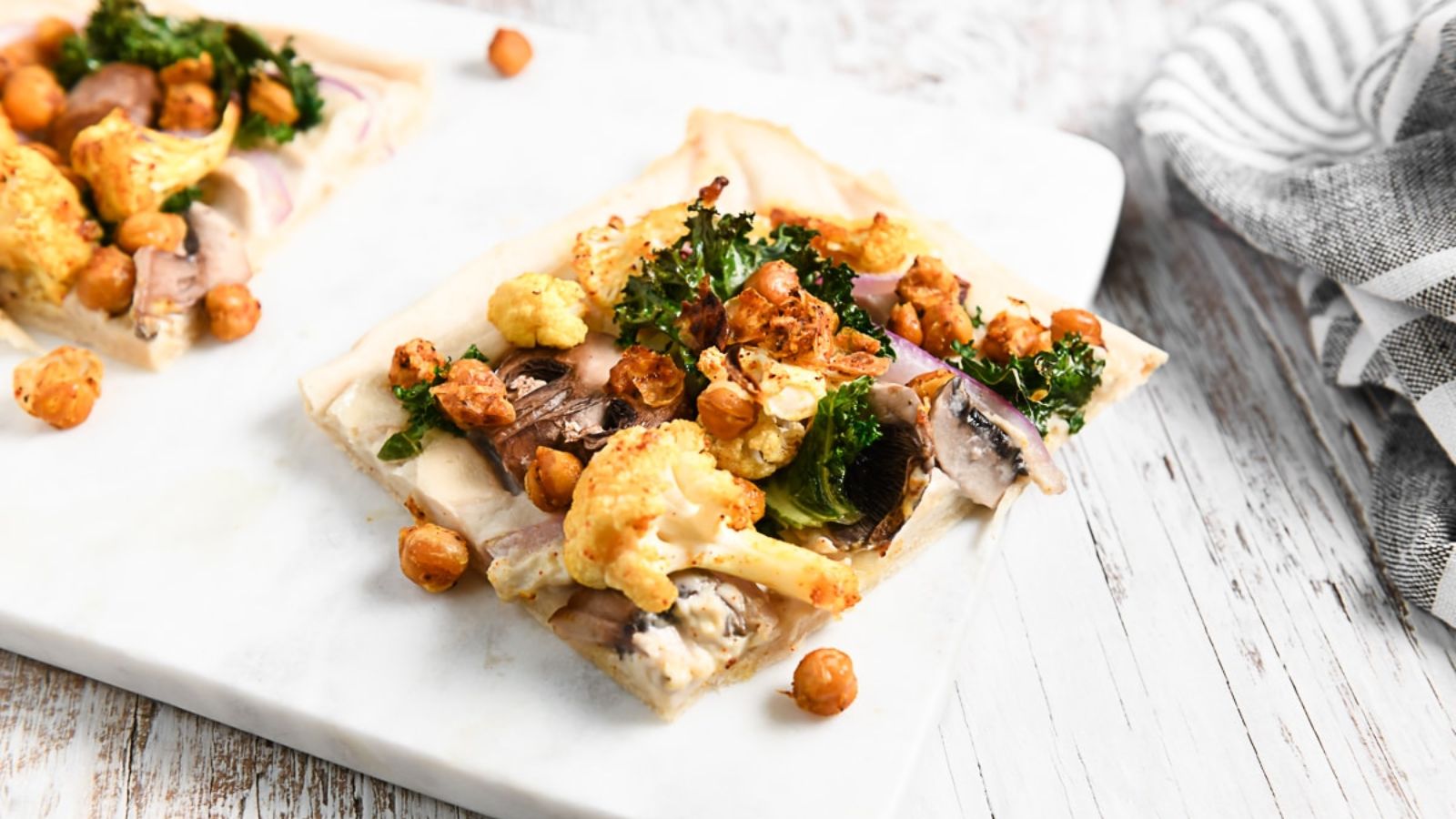 A slice of buffalo chickpea pizza on a plate.