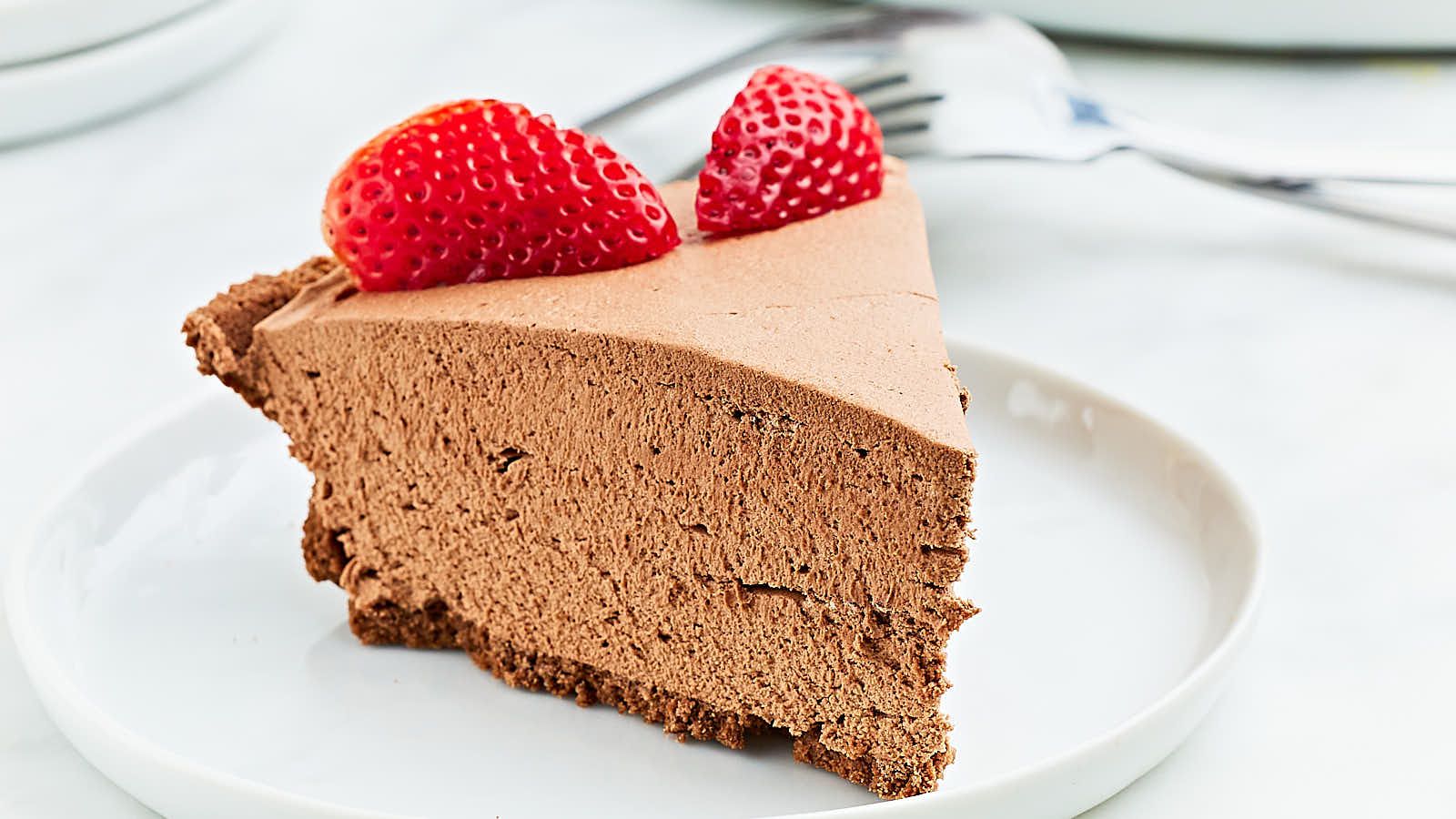 A slice of chocolate cheesecake with raspberries on top.