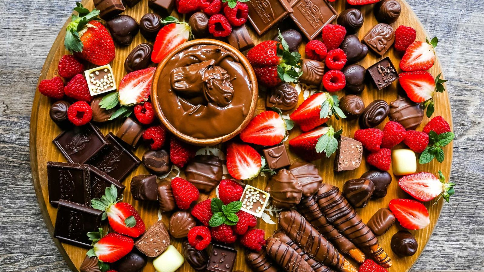 Chocolate desserts with fresh strawberries on a wooden baord.