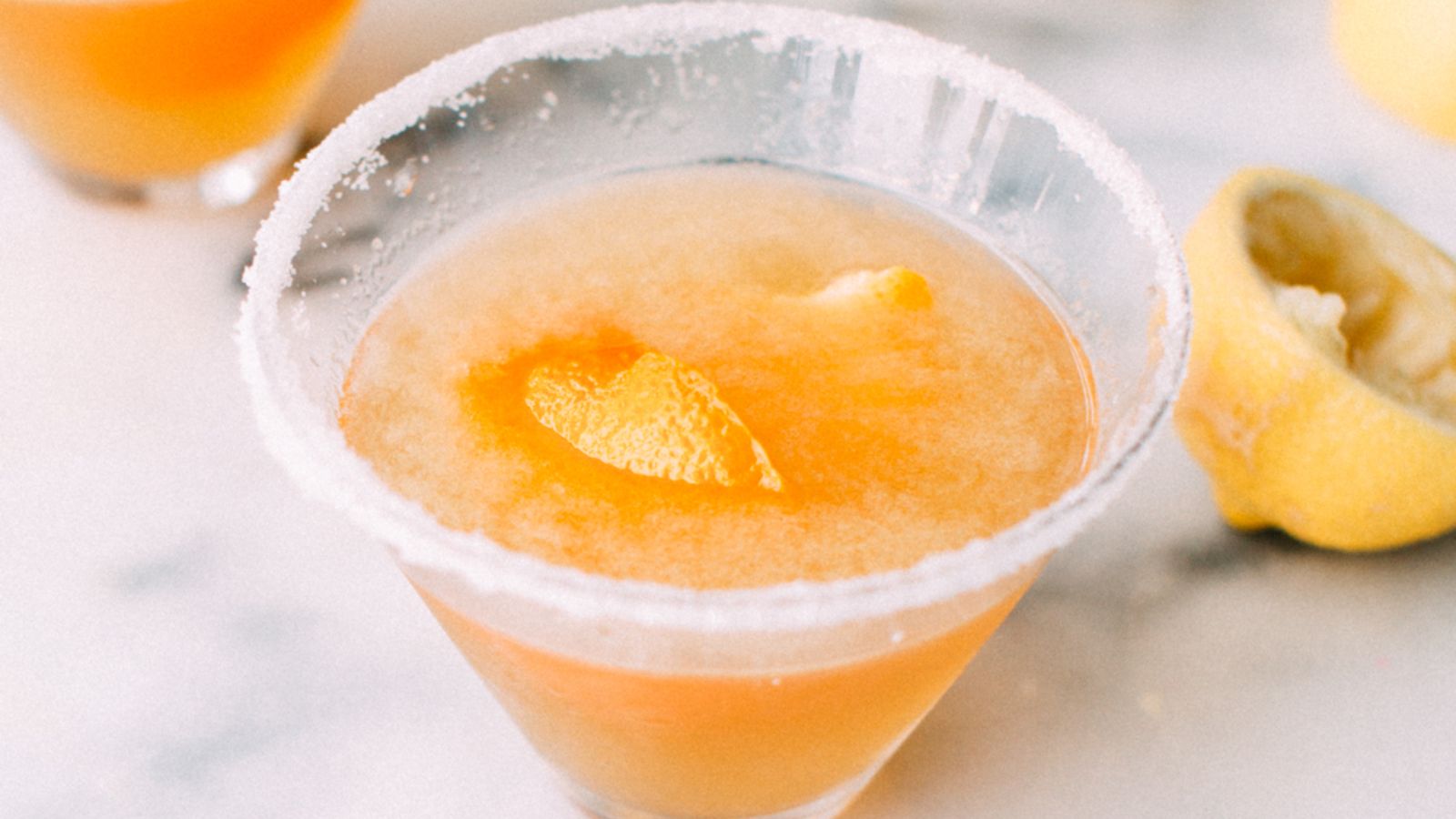 An orange cocktail in a glass.