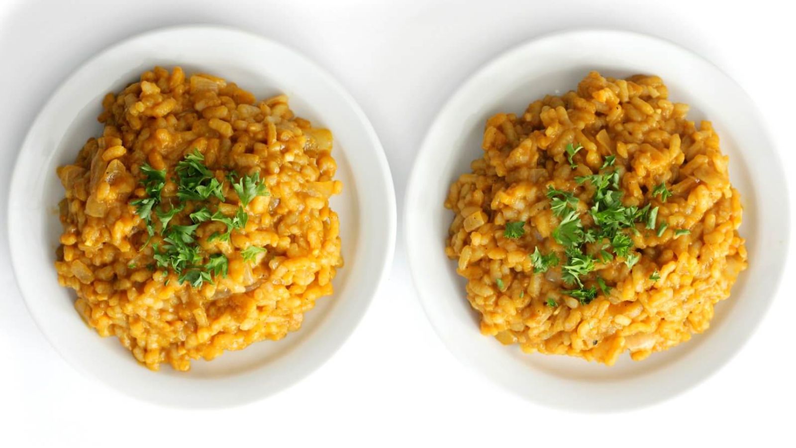 Carrot risotto on two plates.