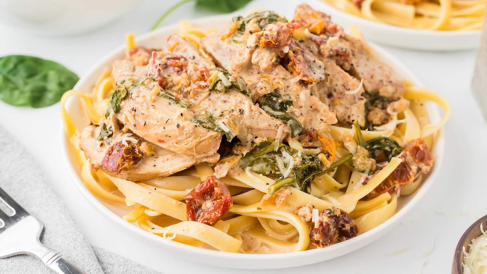 Pasta with sliced chicken on top.