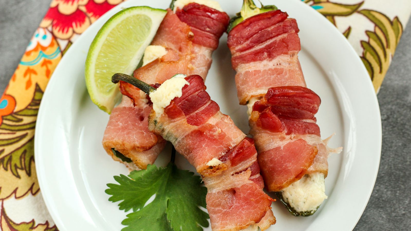 Jalapeno wrapped in bacon on a plate.