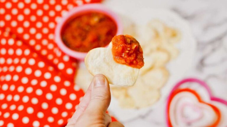 Heart shaped tortilla chips dipped in salsa.