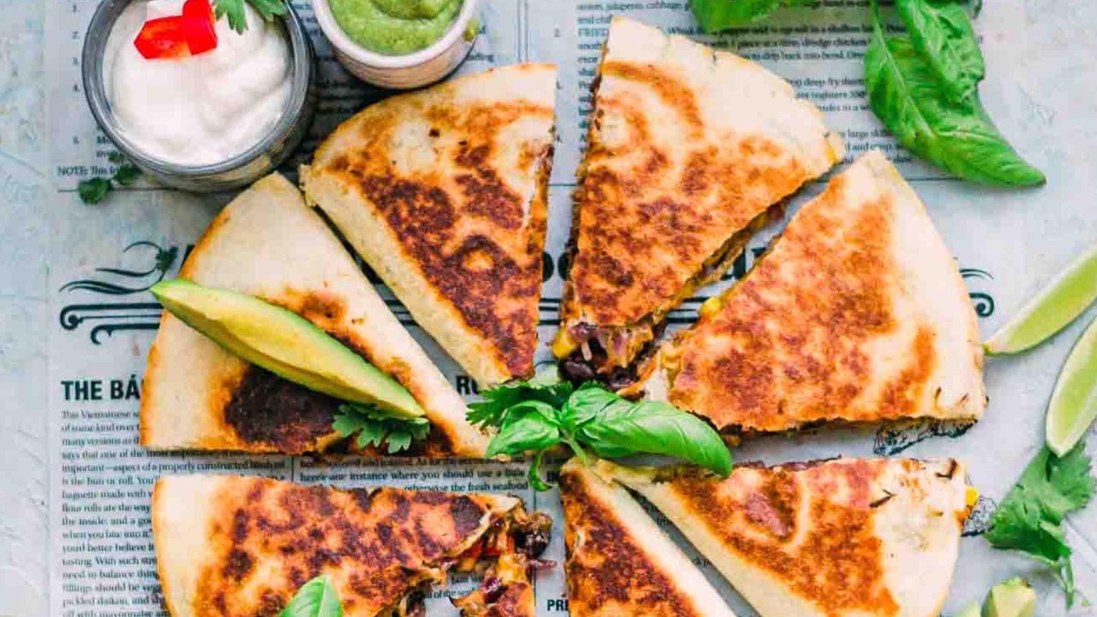 Slices of quesadillas with dips on the side.