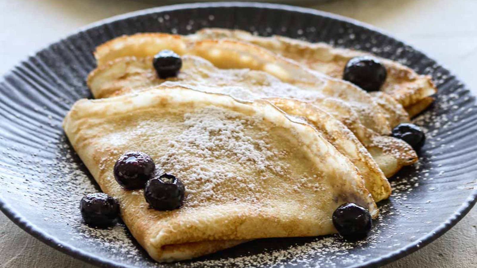 Crepes on a plate with blueberries.