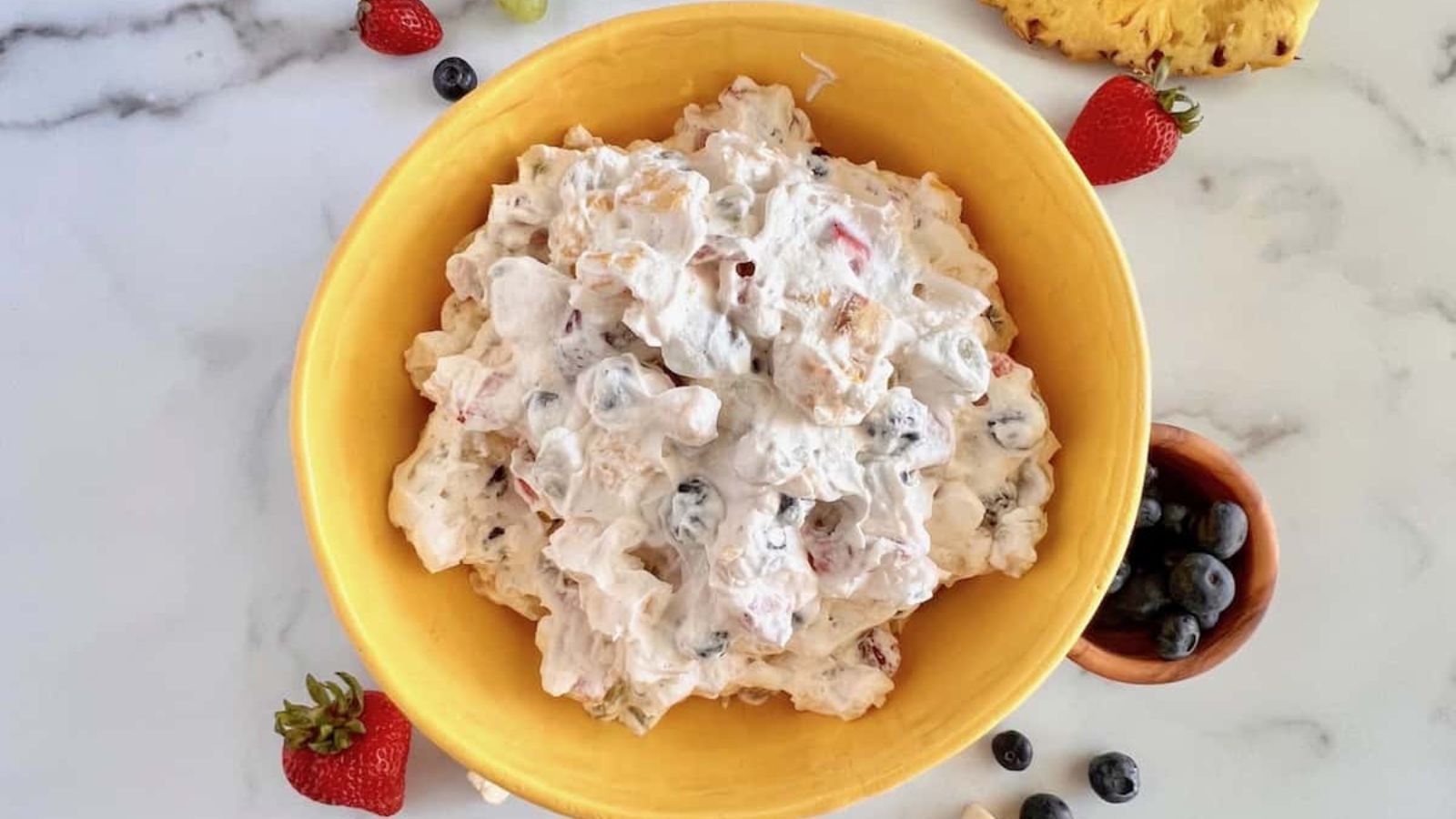Fruit salad with cool whip in a bowl.