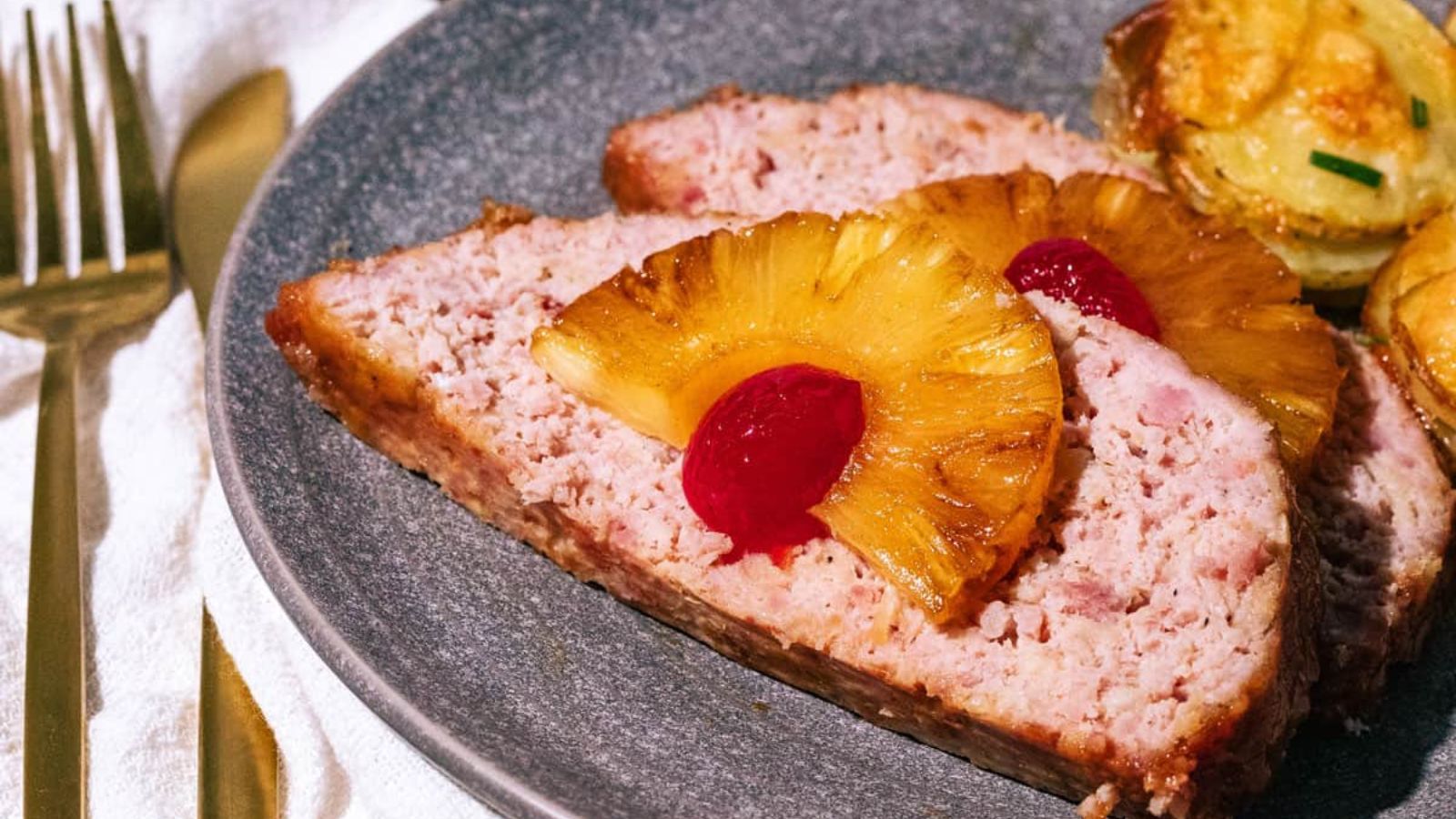 A slice of ham with pineapple on a plate.