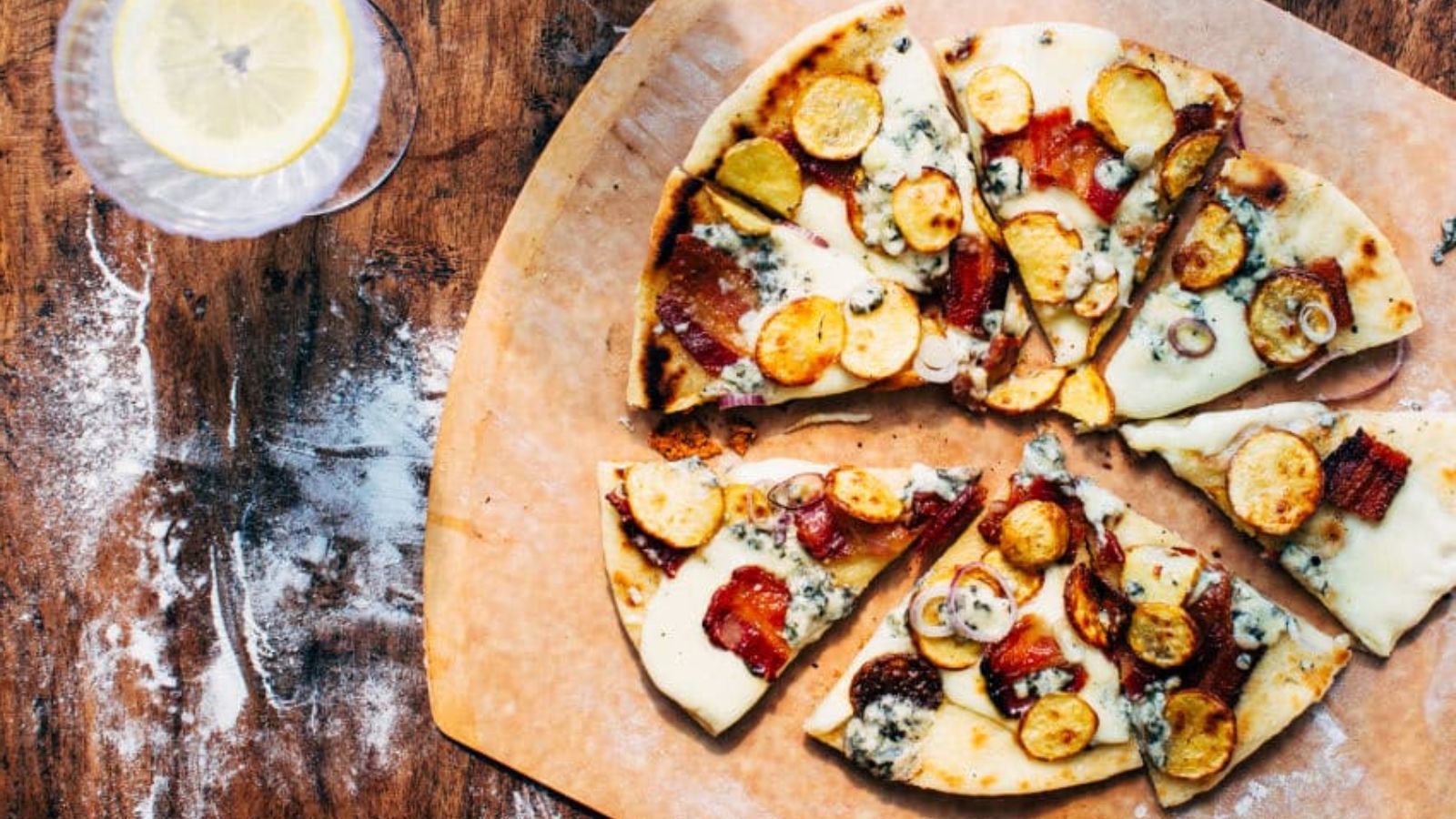 Slices of grilled pizza on a wooden board.