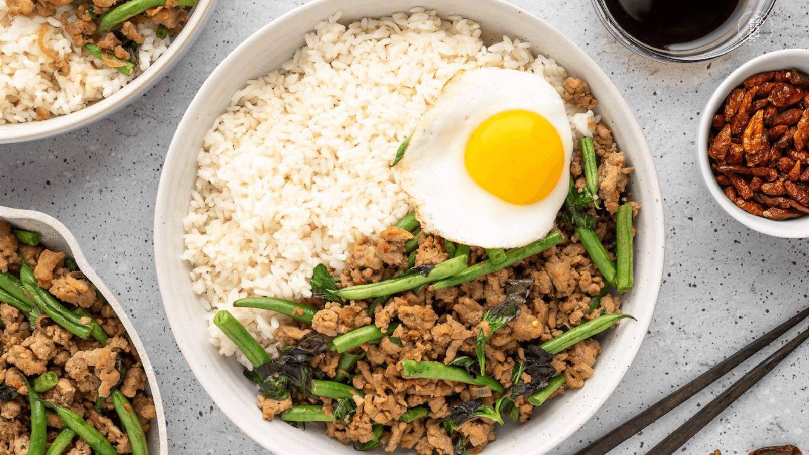 Ground pork with sunny side up egg and rice on a plate.