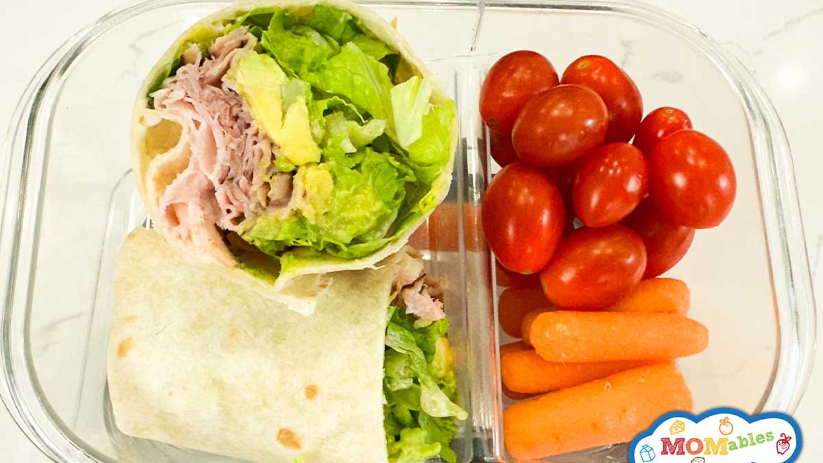 Ham and avocado wrap with tomatoes and carrots.
