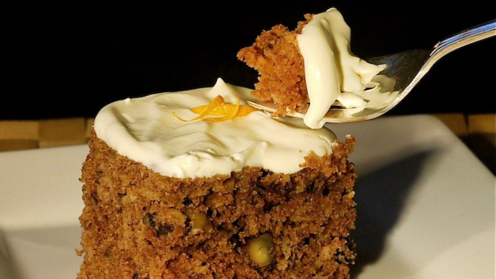 A slice of parsnip cake with orange whipped cream.
