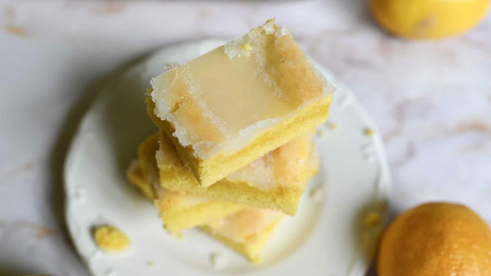 Stack of lemon brownies on a plate.