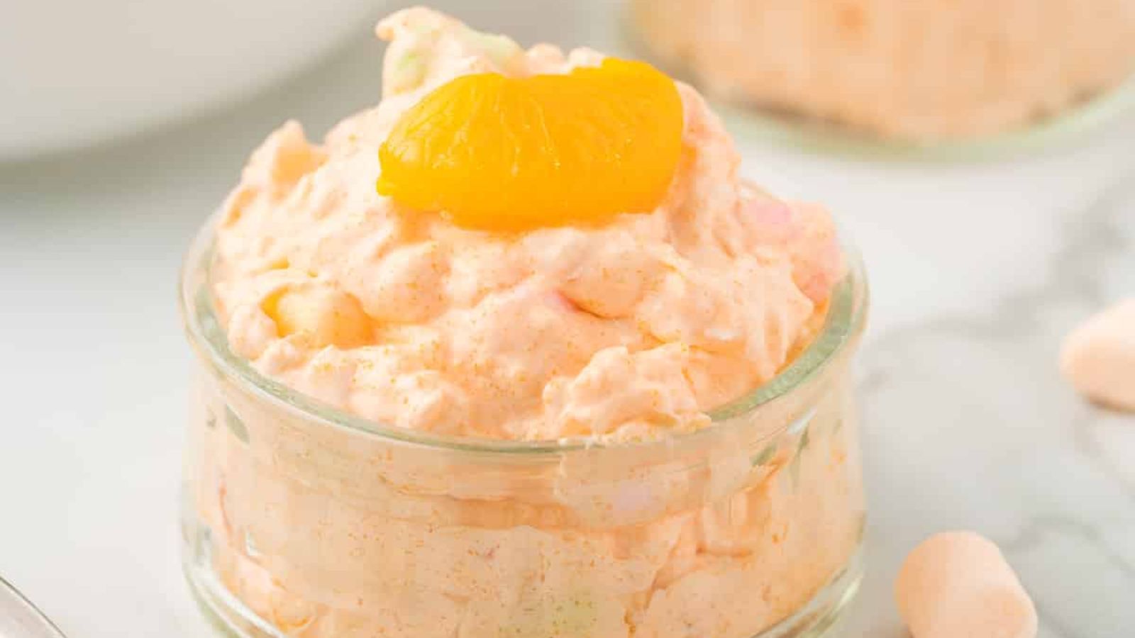 Jello salad with orange in a glass.