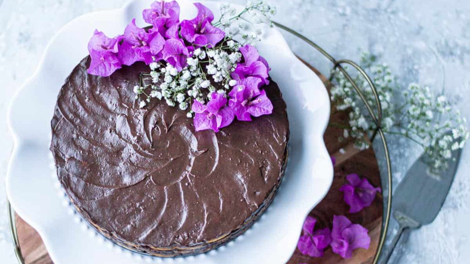 A whole chocolate cake with flowers on top.
