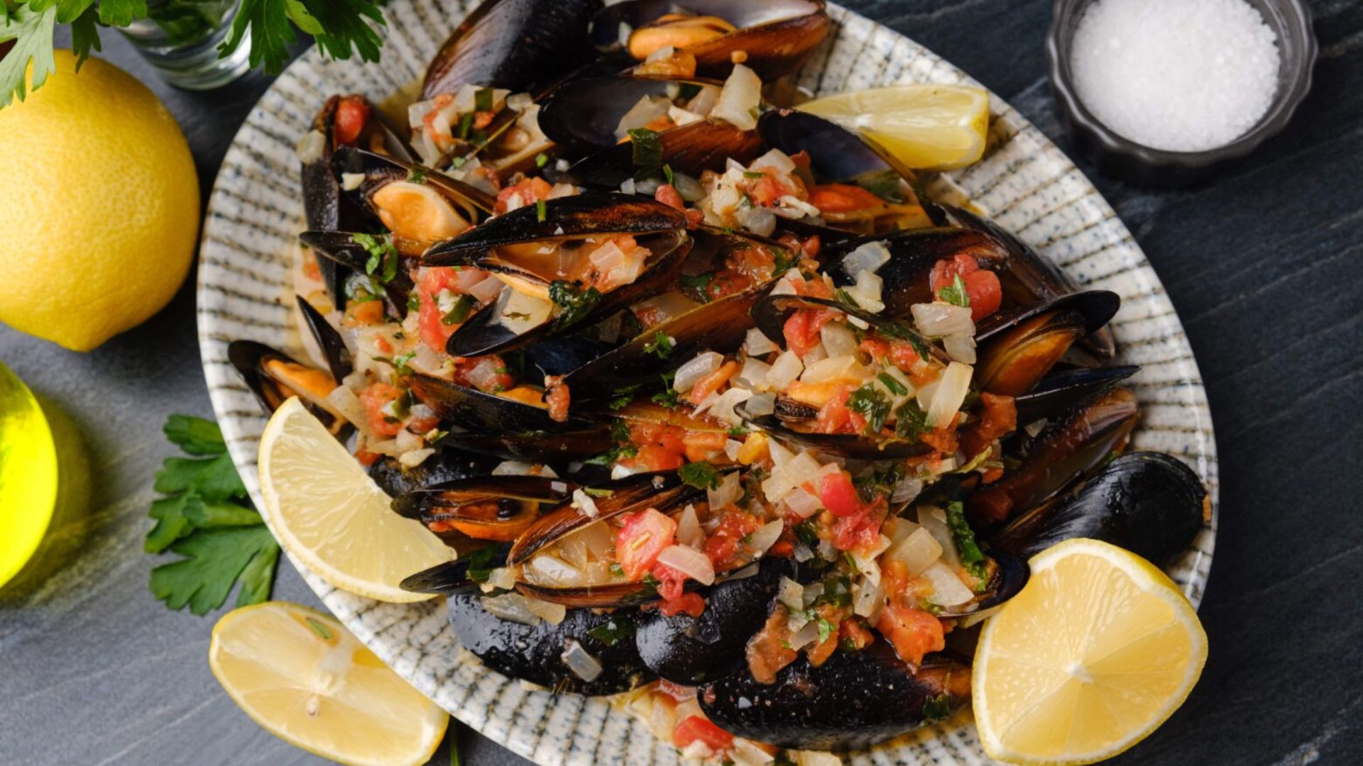 Mussels on a plate with sliced lemons.
