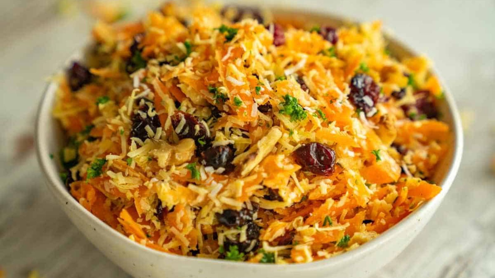 Carrot and coconut salad with cranberries in a bowl.