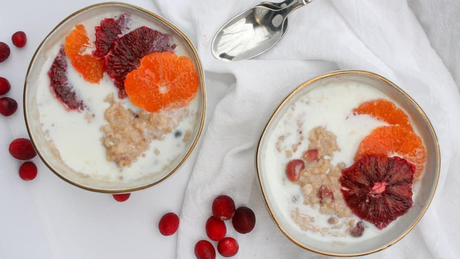 Two bowls of oatmeal with fruits.