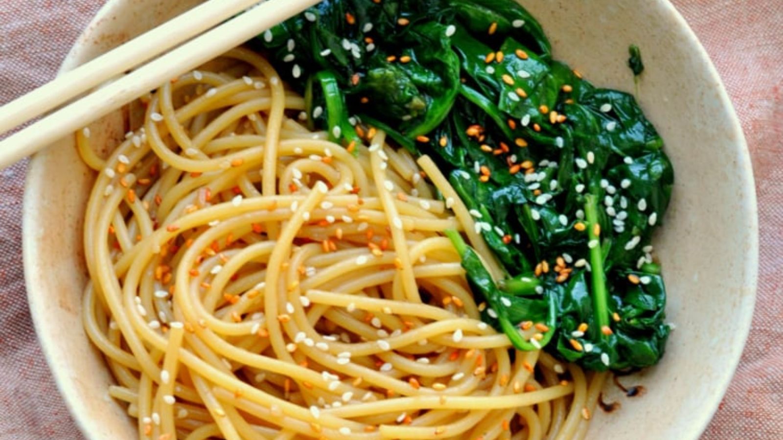 Noodles with wilted greens in a bowl.