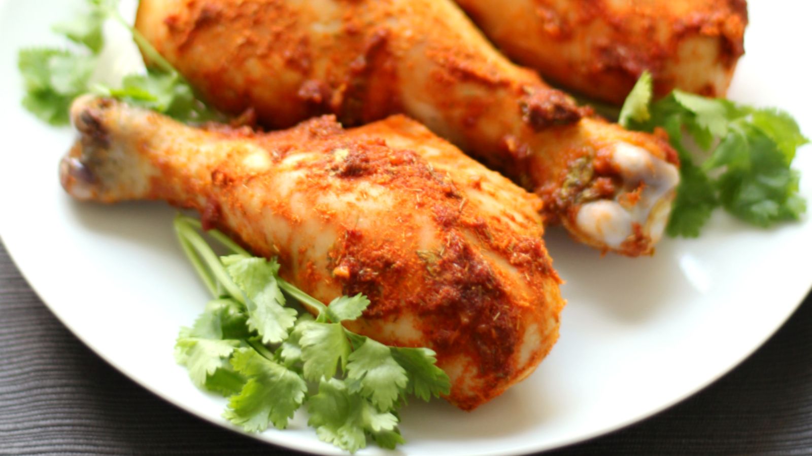 Red thai chicken curry drumstick on a plate.