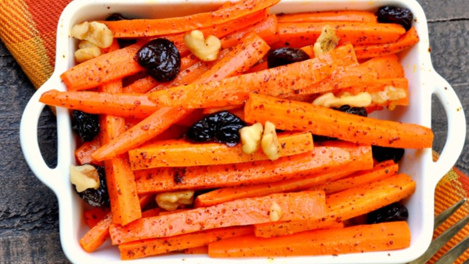 Roasted carrots with walnuts on a tray.