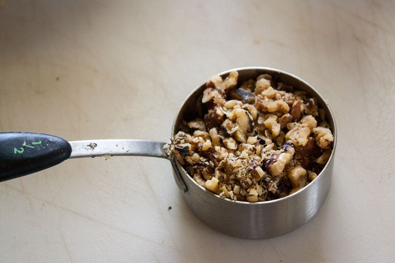 Measuring bowl filled with chopped nuts.