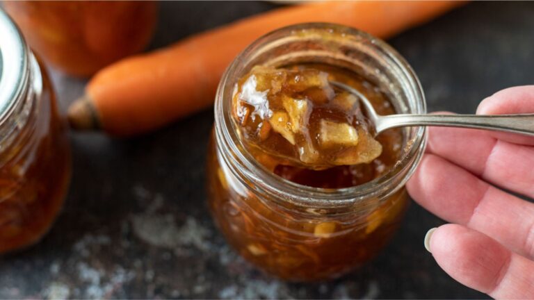 Carrot cake jam in a jar with a spoon scooping some out.