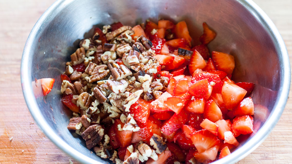Diced strawberries in a bowl with the pecans.